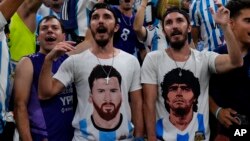 Fans wear shirts of Lionel Messi, left, and Diego Maradona at the Argentina-Croatia World Cup match in Lusail, Qatar, Dec. 13, 2022.