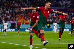 Portugal's Cristiano Ronaldo celebrates after scoring from the penalty spot his side's opening goal against Ghana during a World Cup Group H soccer match at the Stadium 974 in Doha, Qatar, Nov. 24, 2022.