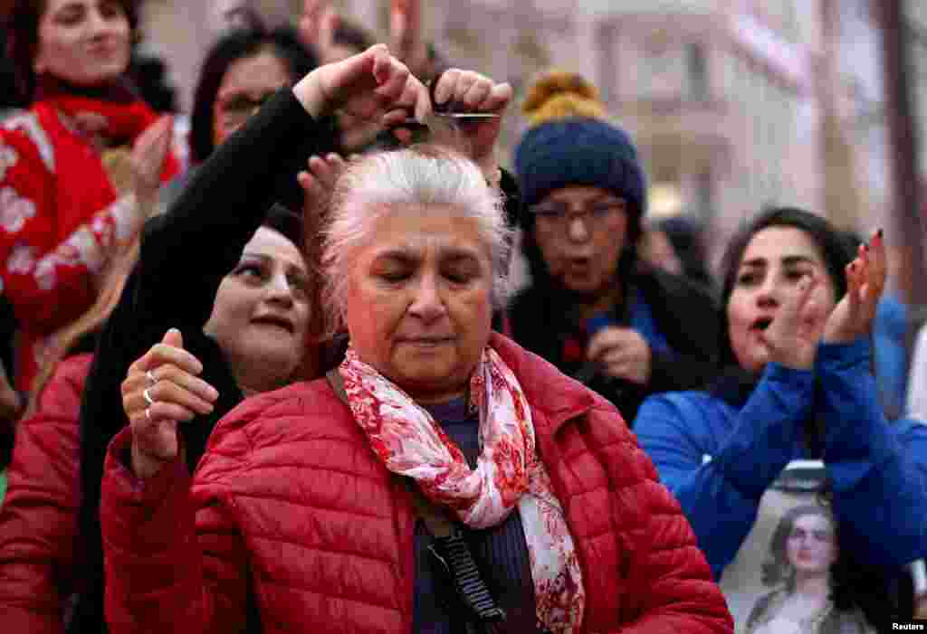 یک زن&nbsp; میانسال معترض در تظاهرات همبستگی در لندن اجازه می&zwnj;دهد تا گیسوانش را به نشانه همبستگی با زنان ایرانی ببرند، شنبه ۵ آذر&nbsp;