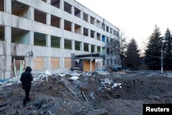 A man looks at the site of a missile strike that occurred during the night in Kramatorsk, as Russia's attack on Ukraine continues, Jan. 8, 2023.