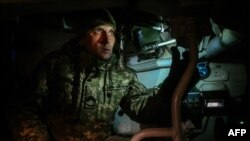 Seorang tentara Ukraina melihat melalui periskop howitzer self-propelled ke arah posisi pasukan Rusia di lapangan dekat posisi garis depan yang dirahasiakan di Ukraina timur, 30 November 2022.