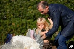 Hunter Biden menurunkan putranya Beau Biden, cucu Presiden Joe Biden, saat mereka melihat kalkun Thanksgiving nasional sebelum upacara pengampunan di Gedung Putih di Washington, Senin, 21 November 2022. (AP Photo/Andrew Harnik)