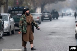 A member of the Taliban security forces walks near a site of an attack at Shahr-e-naw which is city's one of main commercial areas in Kabul, Dec. 12, 2022.
