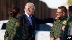 FILE - President Joe Biden talks with U.S. Border Patrol agents as they stand along a stretch of the U.S.-Mexico border in El Paso Texas, Jan. 8, 2023. 