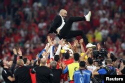 Morocco's players throw Coach Walid Regragui into the air after their victory over Canada that put them atop the Group F standings and into the knockout round of the World Cup at Thumama Stadium in Doha, Qatar, Dec. 1, 2022.