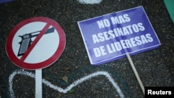 Un cartel que reza "no más asesinatos de mujeres líderes" se ve durante una vigilia para exigir respeto por la vida de los manifestantes, en Bogotá, el 31 de mayo de 2021.