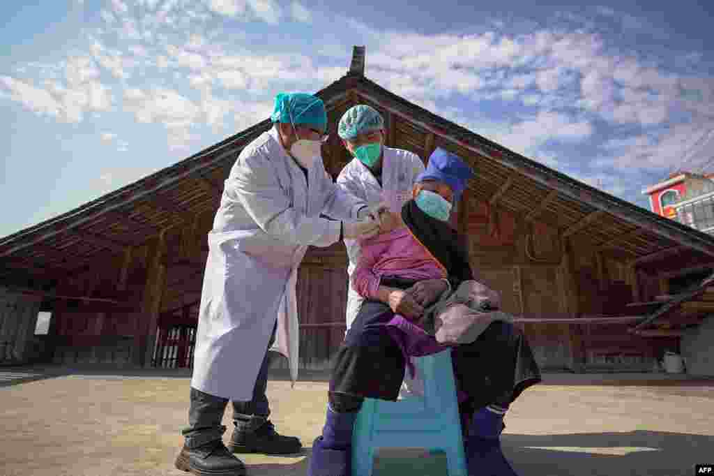 An elderly woman receives a COVID-19 vaccine in Danzhai, in China's southwestern Guizhou province.