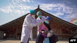 An elderly woman receives a COVID-19 vaccine in Danzhai, in China's southwestern Guizhou province.