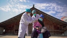 An elderly woman receives a COVID-19 vaccine in Danzhai, in China's southwestern Guizhou province.