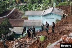Des soldats font évacuer le site d'un glissement de terrain provoqué par le séisme à Cugenang, Cianjur, province de Java Ouest, Indonésie, 22 novembre 2022.