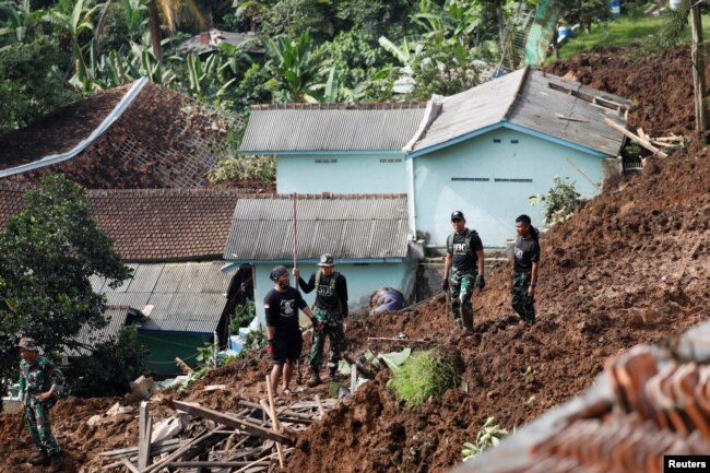 Des soldats font évacuer le site d'un glissement de terrain provoqué par le séisme à Cugenang, Cianjur, province de Java Ouest, Indonésie, 22 novembre 2022.