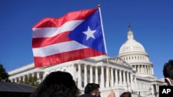 Una mujer ondea la bandera de Puerto Rico durante una conferencia de prensa sobre la estatus de Puerto Rico como estado en el Capitolio de Washington, el 2 de marzo de 2021.