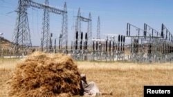 FILE - A farmer naps in a barley field next to an electricity power plant near a village in Mekelle, Tigray, Oct. 25, 2013. Ethiopia's electric company says it has reconnected the capital city to the national grid. 