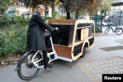 Direktur rumah duka Isabelle Plumereau berpose di atas sepeda jenazahnya, sebuah alternatif dari kendaraan bermotor tradisional, di Paris, Prancis, 2 November 2022. (REUTERS/Yiming Woo)