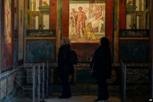 People admire frescoes in a "triclinium", or dining room, called " Hall of Ixium", part of the House of Vettii. (AP Photo/Andrew Medichini)