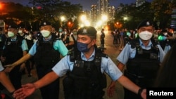 FILE - Police officers disperse people at the closed Victoria Park on the 33rd anniversary of the crackdown on pro-democracy demonstrations at Beijing's Tiananmen Square in 1989, in Hong Kong, June 4, 2022.