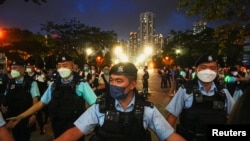 FILE - Police officers disperse people at the closed Victoria Park on the 33rd anniversary of the crackdown on pro-democracy demonstrations at Beijing's Tiananmen Square in 1989, in Hong Kong, June 4, 2022.