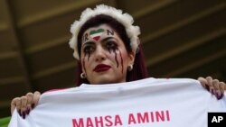 Una mujer muestra una camiseta con el nombre de Mahsa Amini, que murió tras ser detenida por la policía en Irán a los 22 años. Qatar, el 25 de noviembre de 2022.
