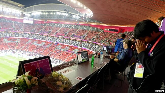 Se colocan flores en memoria del periodista Grant Wahl en su asiento asignado en la fila de prensa en el estadio Al Bayt en Al Khor, Qatar, el 10 de diciembre de 2022.