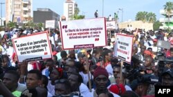 FILE: Senegalese journalists hold banners and shout slogans during the march for the release of their colleague Pope Ale Niang in Dakar on November 18, 2022, arrested for being critical of the government. 