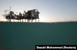 Anak-anak Bajau Laut bermain di geladak gubuk mereka di Laut Sulawesi. (Foto: REUTERS/Bazuki Muhammad)