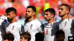 Iran's players line up for the singing of the national anthem ahead of the World Cup group B soccer match between Wales and Iran, at the Ahmad Bin Ali Stadium in Al Rayyan, Qatar, Nov. 25, 2022.