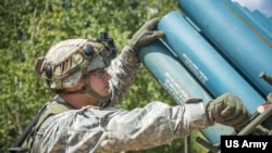 FILE - A US Army Reserve Soldier inspects training mines on an M-136 Volcano mine system at Fort McCoy, Wis., Aug. 12, 2017.