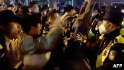 11月27日凌晨时分，愤怒的上海市民走上街头抗议严厉的封控政策。这是当时目击者视频的截屏。这类景象在中国却多地区都有发生。截屏来自法新社。