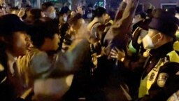 11月27日凌晨时分，愤怒的上海市民走上街头抗议严厉的封控政策。这是当时目击者视频的截屏。这类景象在中国却多地区都有发生。截屏来自法新社。