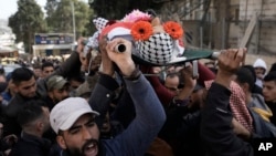 Palestinian mourners carry the body of Ahmad Kahla, 45, during his funeral in the West Bank village of Rammun, Jan. 15, 2023. The Palestinian Health Ministry says Israeli troops have shot and killed the Palestinian man in the occupied West Bank.