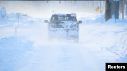 Vehicles drive through blowing snow following a winter storm that hit the Buffalo region on Main St. in Amherst, New York, Dec. 25, 2022. 