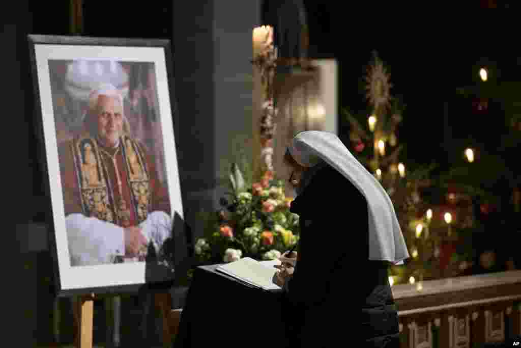 A person signs a book of condolence for Pope Emeritus Benedict XVI at the Saint Magdalena church in Altoetting, Germany, Dec. 31, 2022.&nbsp;Pope Emeritus Benedict XVI, the German theologian who will be remembered as the first pope in 600 years to resign, has died, the Vatican announced Saturday. He was 95.&nbsp;