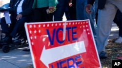 People head to the polls in the runoff election between Democratic Senator Raphael Warnock and Republican challenger Herschel Walker, in Atlanta, Nov. 27, 2022. 