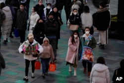 Shoppers return to a popular mall following the easing of pandemic restrictions in Beijing, Jan. 1, 2023.