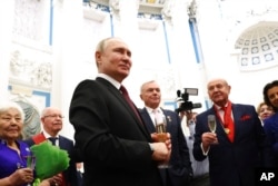 Russian President Vladimir Putin toasts at an awarding ceremony at the Kremlin's St. Catherine Hall in Moscow, Russia, Dec. 20, 2022.