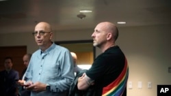 Co-owners of Club Q, Matthew Haynes, left, and Nic Grezcka look on during a news conference about the mass shooting at their bar, Monday, Nov. 21, 2022, in Colorado Springs, Colo.