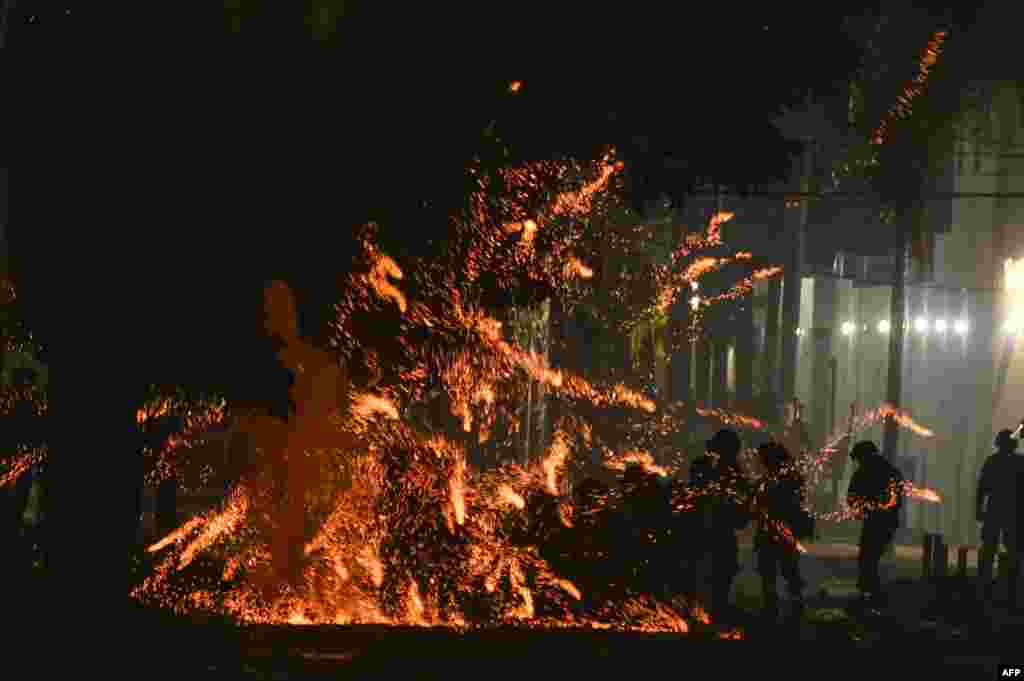 Police officers are struck by flares thrown by demonstrators demanding the release of the governor of Santa Cruz, Luis F. Camacho, at the gates of the Police Departmental Command in Santa Cruz, Bolivia.