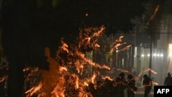 Police officers are struck by flares thrown by demonstrators demanding the release of the governor of Santa Cruz, Luis F. Camacho, at the gates of the Police Departmental Command in Santa Cruz, Bolivia.