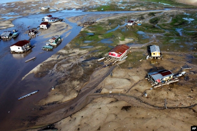 Houseboats sit on land affected by drought near the Solimoes River, in Tefe, Amazonas state, Brazil, on Oct. 19, 2022.