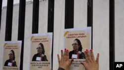 Una mujer coloca volantes en apoyo a la fiscal guatemalteca Virginia Laparra, mientras asiste a una audiencia judicial en Ciudad de Guatemala, el martes 7 de junio de 2022.