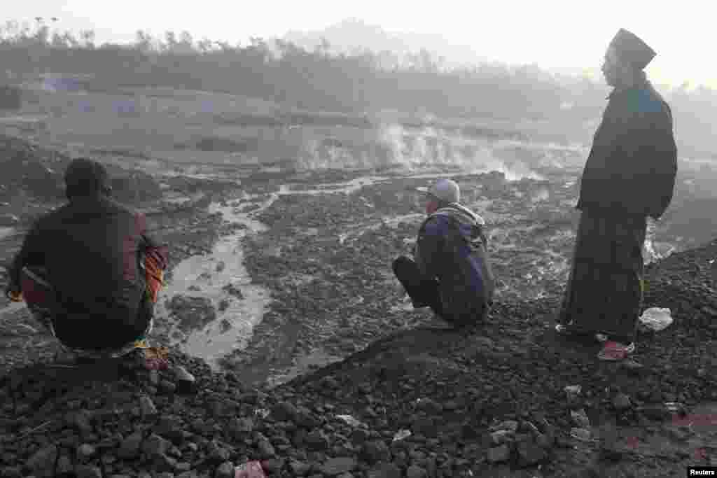 Habitantes de la zona, que dejaron sus viviendas en busca de un refugio, contemplan a lo lejos el volcán Semeru que hizo erupción en la tarde del domingo&nbsp;en Lumajang, provincia indonesia de Java Oriental.
