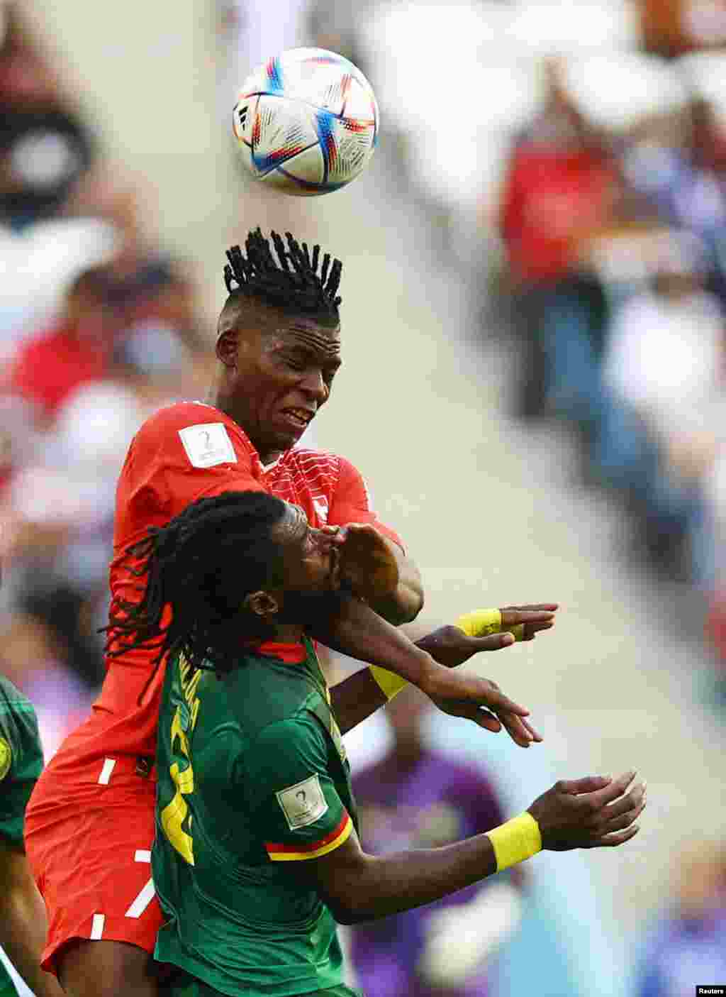 Switzerland&#39;s Breel Embolo jumps for a header with Cameroon&#39;s Andre-Frank Zambo Anguissa during the World Cup group G soccer match between Switzerland and Cameroon at the Al Janoub Stadium in Al Wakrah, Qatar.