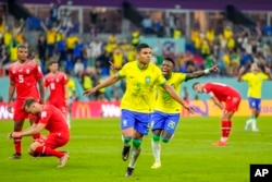 Brazil's Casemiro, center, celebrates after scoring his side's opening goal during the World Cup group G soccer match between Brazil and Switzerland, at the Stadium 974 in Doha, Qatar, Nov. 28, 2022.