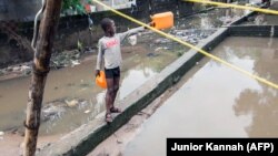 ARCHIVES - Un garçon se tient dans une rue de Limete à Kinshasa le 9 décembre 2015 après un débordement de la rivière N'djili près de l'embouchure de Matete.
