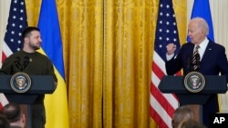 Ukrainian President Volodymyr Zelenskyy listens as President Joe Biden speaks during a news conference in the East Room of the White House in Washington, Dec. 21, 2022.