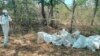 FILE - Forensic investigators remove bodies, Oct. 21, 2022 in the Mzimba District of Malawi where officials exhumed the bodies of 26 suspected Ethiopian migrants from a mass grave.