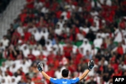 Morocco's goalkeeper Yassine Bounou celebrates with supporters winning the Qatar 2022 World Cup Group F football match between Canada and Morocco on December 1, 2022.