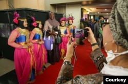 Seorang partisipan KUPI II berfoto bersama penari yang mengisi acara pembukaan di UIN Walisongo Semarang, Rabu (23/11). (Foto: AMAN Indonesia)