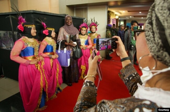 Seorang partisipan KUPI II berfoto bersama penari yang mengisi acara pembukaan di UIN Walisongo Semarang, Rabu (23/11). (Foto: AMAN Indonesia)