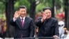 FILE - In this photo released by China's Xinhua News Agency, visiting Chinese President Xi Jinping, left, and North Korean leader Kim Jong Un wave from an open top limousine as they travel along a street in Pyongyang, North Korea, on June 20, 2019. 